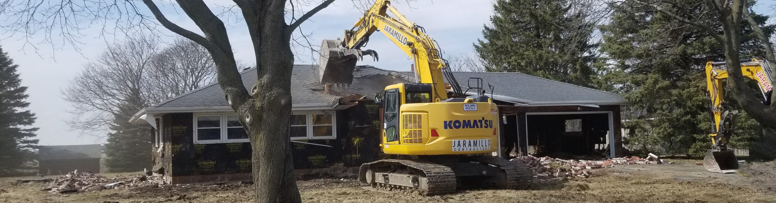 An excavator razing a house