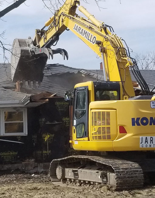 An excavator razing a house